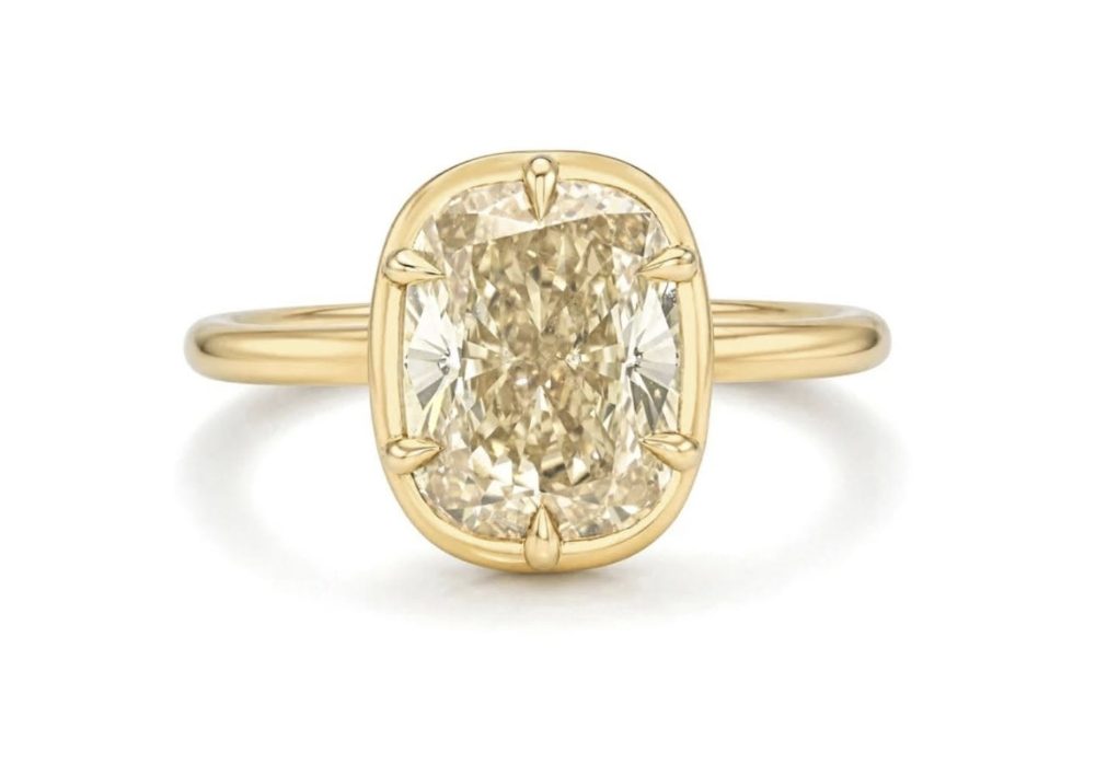 Warm elongated center diamond framed by a yellow-colored setting