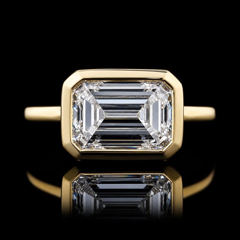 Rectangular colorless stone surrounded by a yellow-toned bezel