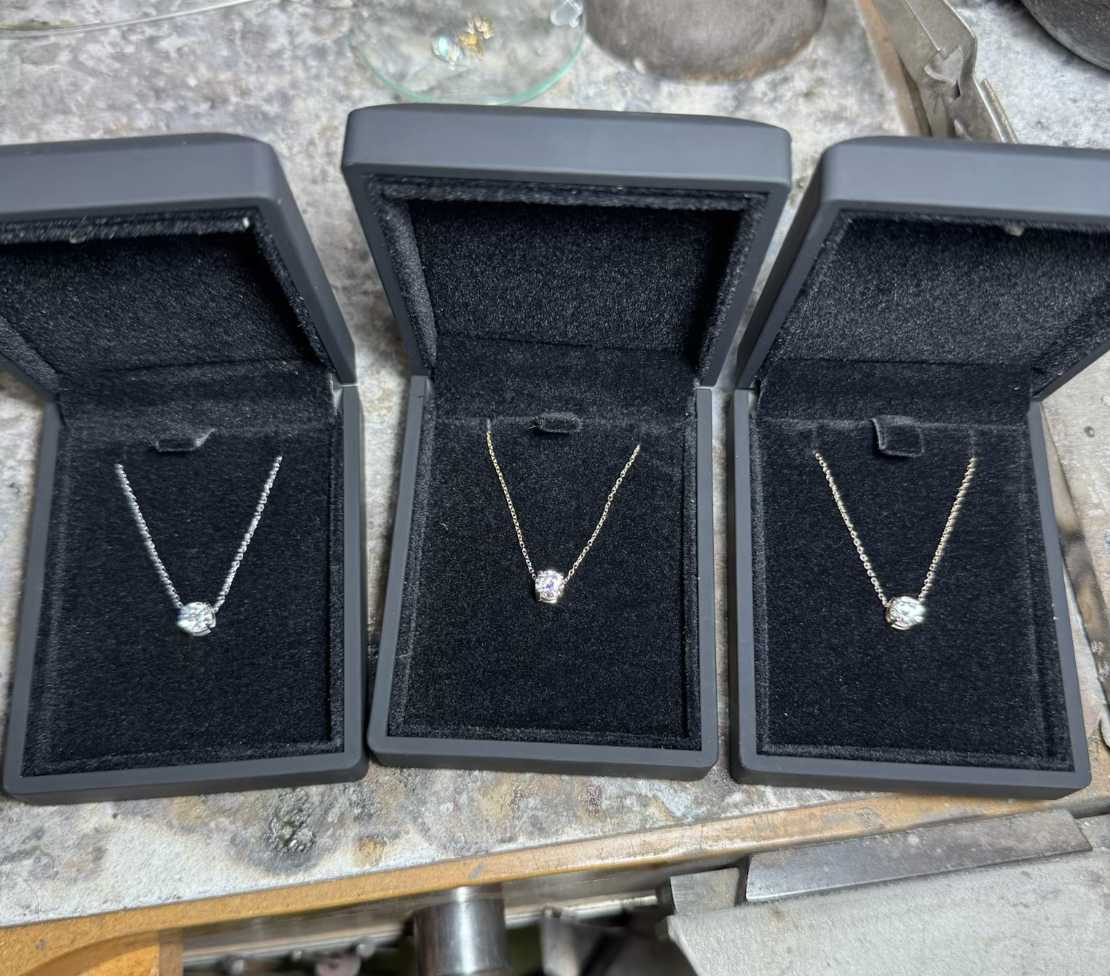 Three finished lab-grown diamond necklaces in presentation boxes at Ring Mint’s Pennsylvania studio.